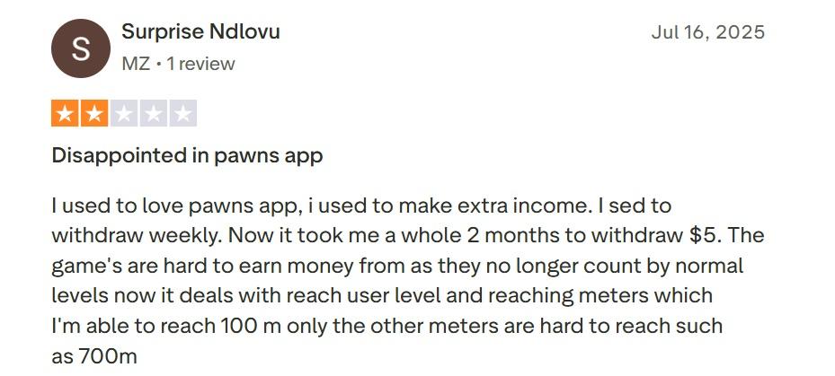 User review expressing disappointment in the "Pawns" app, highlighting difficulty in earning money and slow withdrawal process.